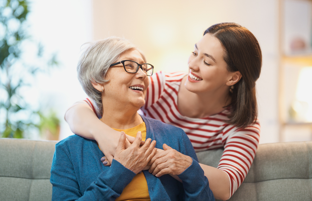 A smiling senior woman wearing eyeglasses enjoys time with her family, showcasing the comfort and clarity that come from regular visits to the optometrist for proper vision care – Optometrist.