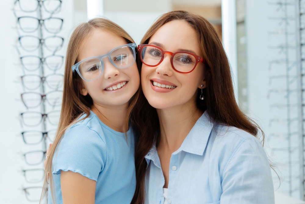 Mother and Daughter Choosing Stylish Eyeglasses – Georgetown Eyeglasses A smiling mother and daughter wearing colorful frames enjoy their visit to the optical shop, exploring fun, stylish eyeglasses designed for all ages. – Georgetown Eyeglasses