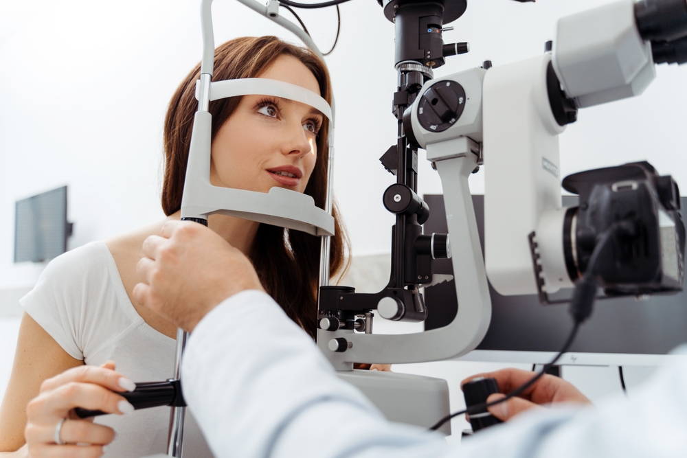 A patient sits at a slit lamp machine while the eye doctor performs a close-up evaluation of the eye’s structures. This essential diagnostic test helps assess vision concerns, dryness, infections, and overall ocular health – Eye Doctor.